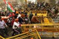 NEW DELHI, INDIA - JANUARY 26 : Indian Farmers attempt to break a barricade farmers who marched to the capital during India's Republic Day celebrations in New Delhi on India January 26, 2021, The thousands of farmers drove a convoy of tractors into the Indian capital as the nation celebrated Republic Day on Tuesday in the backdrop of agricultural protests that have grown into a rebellion and rattled the government. (Photo by Imtiyaz Khan/Anadolu Agency via Getty Images)