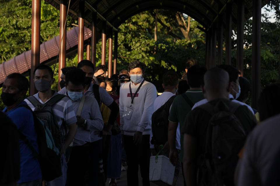 A passenger wearing face mask waits in line at a bus stop in Manila, Philippines on Sept. 8, 2022. Philippine President Ferdinand Marcos Jr. is extending a state of calamity declared by his predecessor more than two years ago to deal with continuing concerns over the coronavirus pandemic, an official said Monday, Sept. 12, 2022. (AP Photo/Aaron Favila)