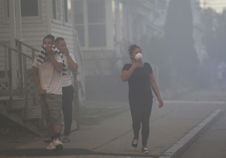 <em>People were left having to cover their faces as smoke inundated the areas (Picture: Jessica Rinaldi/The Boston Globe via AP)</em>