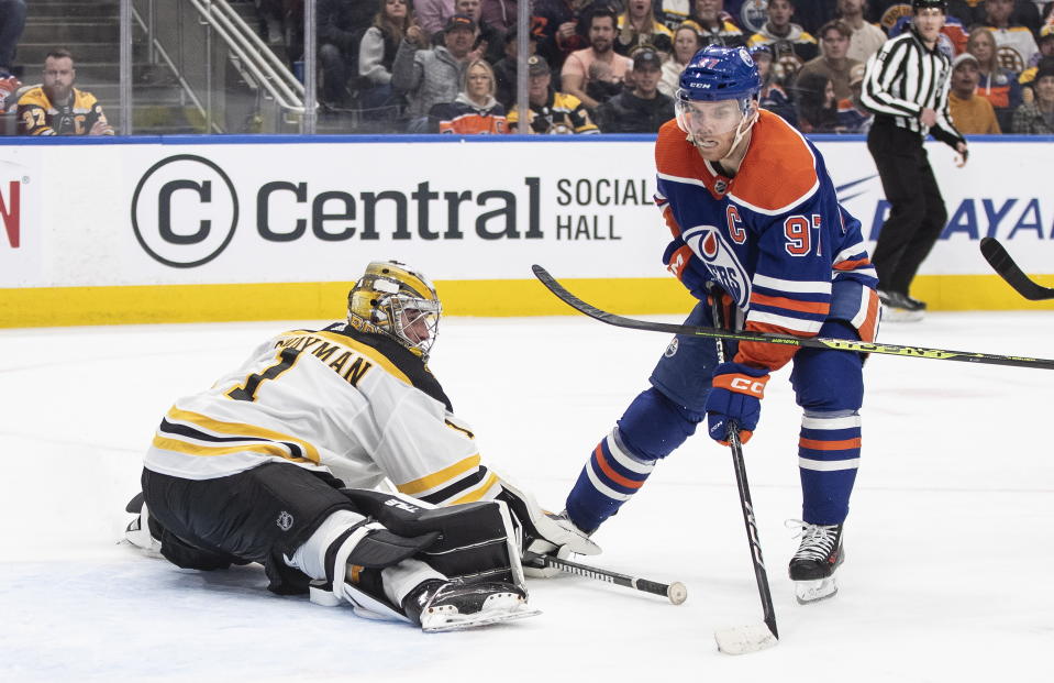Boston Bruins goalie Jeremy Swayman (1) is scored against by Edmonton Oilers' Connor McDavid (97) during second-period NHL hockey game action in Edmonton, Alberta, Monday, Feb. 27, 2023. (Jason Franson/The Canadian Press via AP)