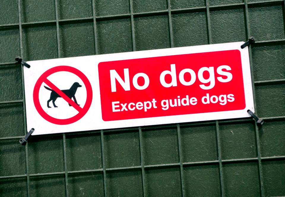 A sign on a fence reads, “No dogs except guide dogs.”