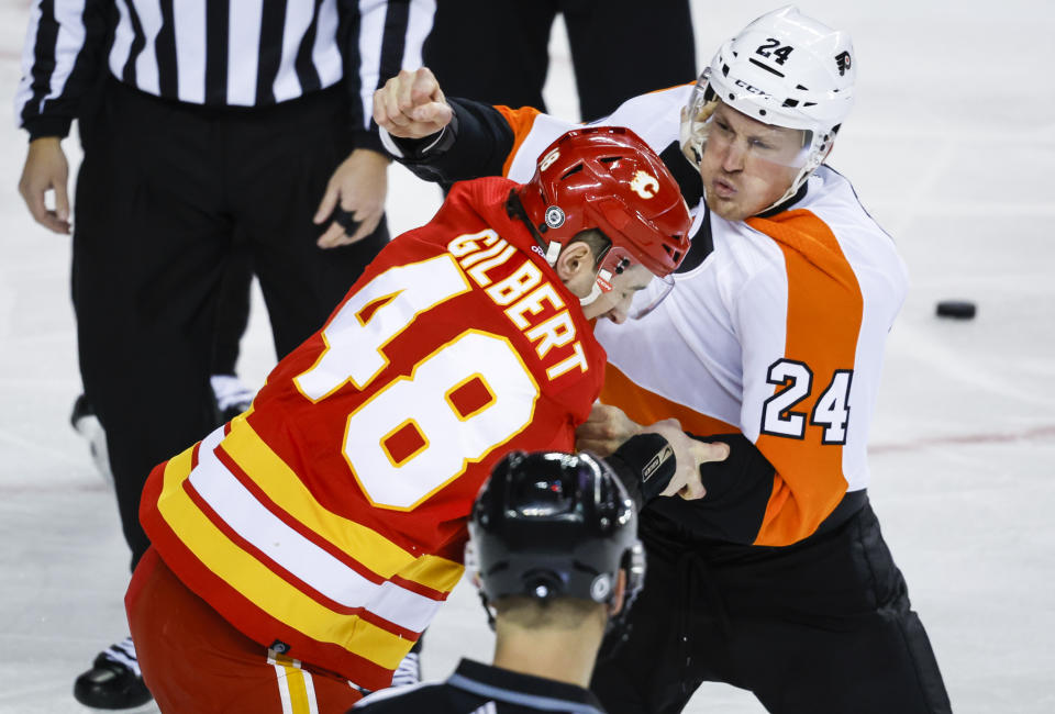 Philadelphia Flyers defenseman Nick Seeler, right, fights with Calgary Flames defenseman Dennis Gilbert during the first period of an NHL hockey game in Calgary, Alberta, Monday, Feb. 20, 2023. (Jeff McIntosh/The Canadian Press via AP)