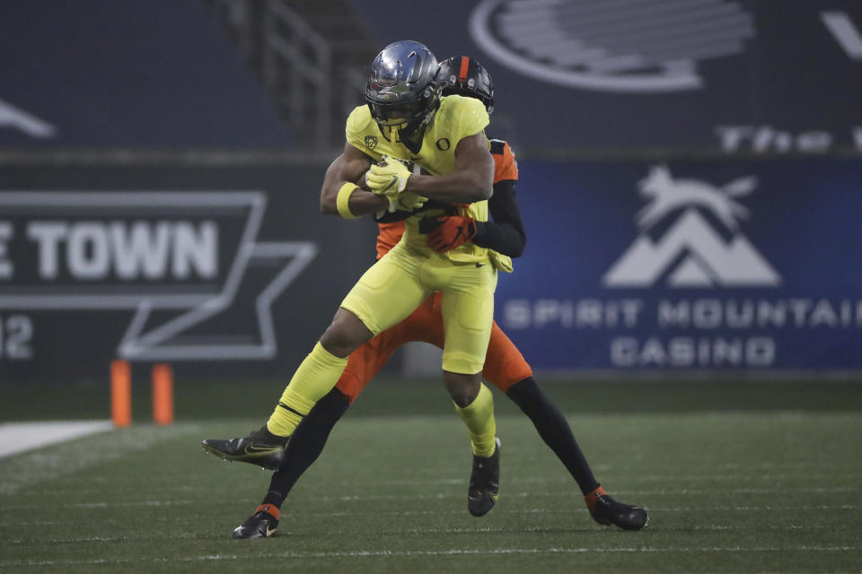 Oregon wide receiver Johnny Johnson III (3) is brought down by Oregon State defensive back Nahshon Wright during the first half of an NCAA college football game in Corvallis, Ore., Friday, Nov. 27, 2020. (AP Photo/Amanda Loman)