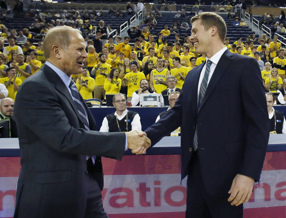 Michigan head coach John Beilein, left, greets his son, Le Moyne head coach Patrick Beilein, right, before their NCAA basketball game Friday, Nov. 6, 2015, in Ann Arbor, Mich. (AP Photo/Duane Burleson)