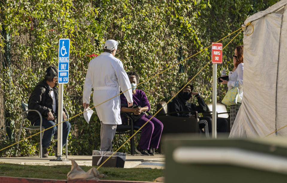 Patients wait in line for medical evaluation next to medical tents set at the CHA Hollywood Presbyterian Medical Center in Los Angeles Friday, Dec. 18, 2020. Increasingly desperate California hospitals are being "crushed" by soaring coronavirus infections, with one Los Angeles emergency doctor predicting that rationing of care is imminent. The most populous state recorded more than 41,000 new confirmed cases and 300 deaths, both among the highest single-day totals during the pandemic. In the last week, California has reported more than a quarter-million cases and 1,500 deaths. (AP Photo/Damian Dovarganes)