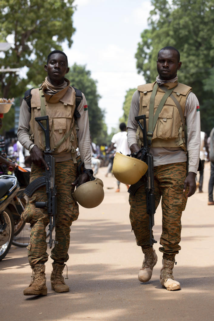 Soldiers loyal to Capt. Ibrahim Traore walk in the streets of Ouagadougou, Burkina Faso, Sunday, Oct. 2, 2022. Burkina Faso's new junta leadership is calling for calm after the French Embassy and other buildings were attacked. (AP Photo/Kilaye Bationo)