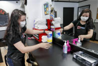 Stylist Kayla Addink arranges items in her workspace Thursday, June 4, 2020, as she prepares for her first day back on the job at the West View Barber Shop when most of southwest Pennsylvania loosens COVID-19 restrictions on Friday in West View, Pa. (AP Photo/Keith Srakocic)