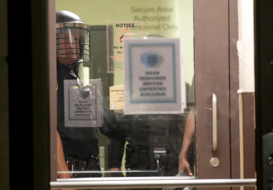 Aug 23, 2020; Kenosha, WI, USA; Kenosha police look out from inside the Kenosha Police Department as protesters gather outside in Kenosha on Sunday, Aug. 23, 2020. Kenosha police shot a man Sunday evening, setting off unrest in the city after a video appeared to show the officer firing several shots at close range into the man's back.Mandatory Credit: Mike De Sisti/Milwaukee Journal Sentinel via USA TODAY NETWORK/Sipa USA