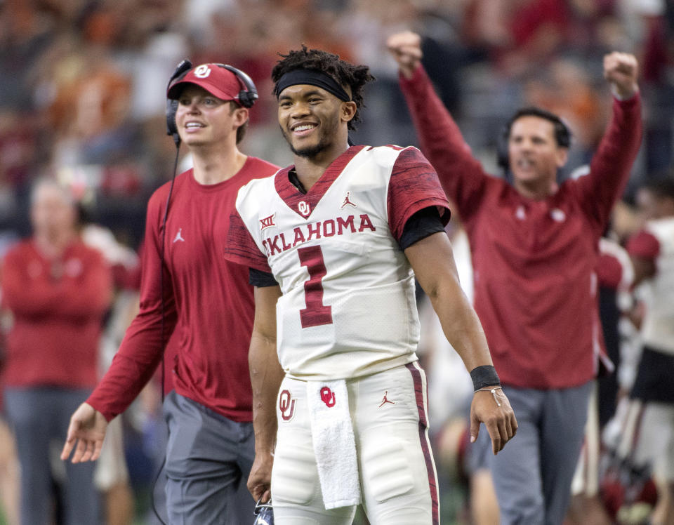 FILE - In this Dec. 1, 2018, file photo, Oklahoma quarterback Kyler Murray (1) celebrates on the sidelines after throwing a touchdown against Oklahoma during the second half of the Big 12 Conference championship NCAA college football game, in Arlington, Texas. A record number of college football players are bypassing remaining years of eligibility to enter the NFL draft, including Heisman Trophy winner Kyler Murray. (AP Photo/Jeffrey McWhorter, File)