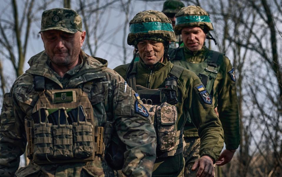 Ukrainian soldiers walk together at their position on the frontline near Bakhmut - AP