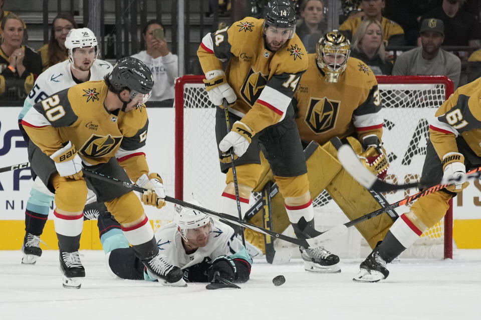 Seattle Kraken center Jaden Schwartz dives to try and knock the puck away from Vegas Golden Knights center Chandler Stephenson (20) during the second period of an NHL hockey game Tuesday, Oct. 10, 2023, in Las Vegas. (AP Photo/John Locher)