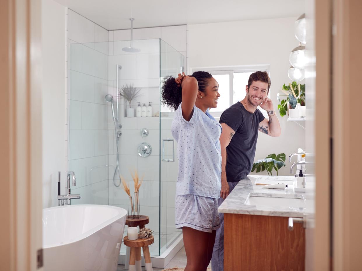 Couple getting ready in the bathroom.