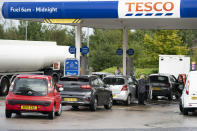 Members of the public are seen at a petrol station in Manchester, England, Monday, Sept. 27, 2021. British Prime Minister Boris Johnson is said to be considering whether to call in the army to deliver fuel to petrol stations as pumps ran dry after days of panic buying. ( AP Photo/Jon Super)