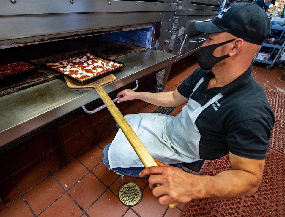 Bernardo Matute, of Trenton, pulls out a Brooklyn pizza at Piccolo Trattoria in Newtown, on Friday, Feb. 26, 2021.