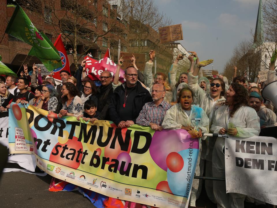 Counter-protestors carry a banner during a demonstration of right-wing extremists in Dortmund on April 14, 2018.