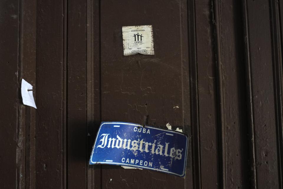 A census sticker hangs on a door, decorated with the name of the city's baseball team, at a dilapidated mansion where six families live on Villegas Street in Havana, Cuba, Thursday, Oct. 5, 2023. Cuba’s Director of Housing Vivian Rodríguez said in Oct. that the island has a housing deficit of 800,000 homes. (AP Photo/Ramon Espinosa)