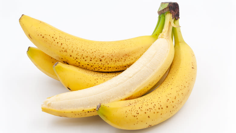 bunch of bananas with one half peeled