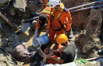 Search and rescue workers help rescue a person trapped in rubble following an earthquake and tsunami in Palu, Central Sulawesi, Indonesia, September 30. Antara Foto/Darwin Fatir/via REUTERS.