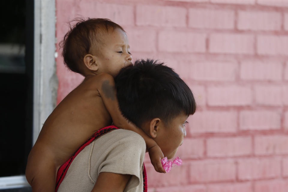 A Yanomami youth carries a toddler on his shoulders at the Saude Indigenous House, a center responsible for supporting and assisting Indigenous people in Boa Vista, Roraima state, Brazil, Wednesday, Jan. 25, 2023. The government declared a public health emergency for the Yanomami people in the Amazon, who are suffering from malnutrition and diseases such as malaria. (AP Photo/Edmar Barros)