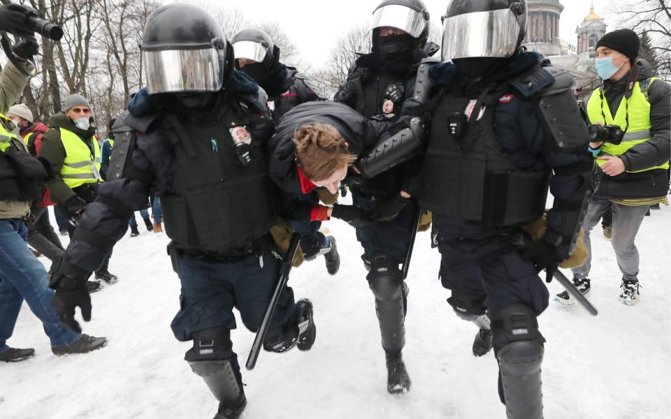 Riot police officers detain a participant in an unauthorized rally in support of Russian opposition activist Alexei Navalny in St. Petersburg - Alexander Demianchuk /TASS