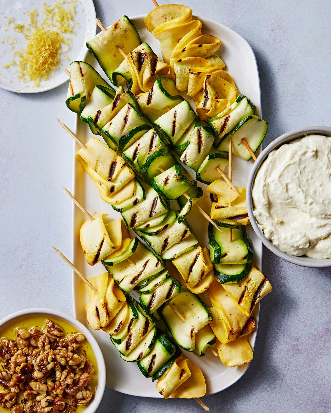 skewered and grilled zucchini planks topped with herby whipped ricotta and crunchy toasted walnuts