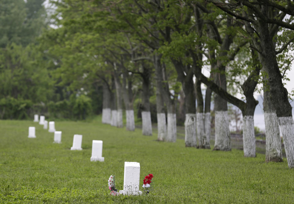 FILE - This May 23, 2018, file photo, shows graves marked by white markers on Hart Island in New York. New York City's mayor signed a bill on Wednesday, Dec. 4, 2019, that transfers control of the nation's largest public burial ground from the correction department to the parks department. (AP Photo/Seth Wenig, File)