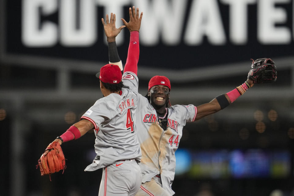 Cincinnati Reds second baseman Santiago Espinal (4) and shortstop Elly De La Cruz (44) celebrate after winning 7-2 over the Los Angeles Dodgers in a baseball game in Los Angeles, Thursday, May 16, 2024. (AP Photo/Ashley Landis)