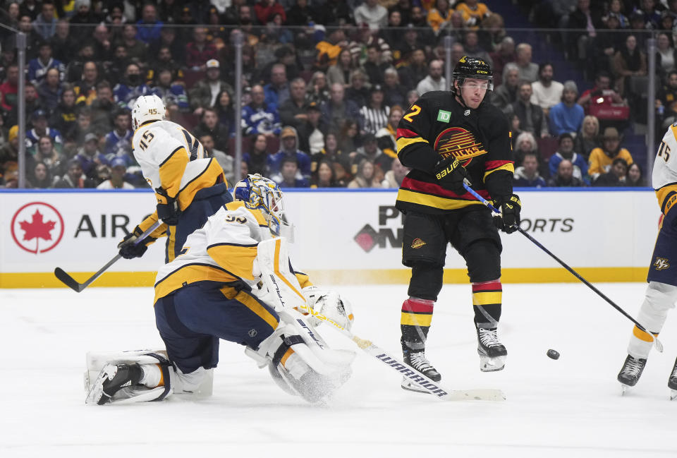 Nashville Predators goalie Kevin Lankinen, front left, comes out of his net to play the puck away from Vancouver Canucks' Anthony Beauvillier during the first period of an NHL hockey game Tuesday, Oct. 31, 2023, in Vancouver, British Columbia. (Darryl Dyck/The Canadian Press via AP)