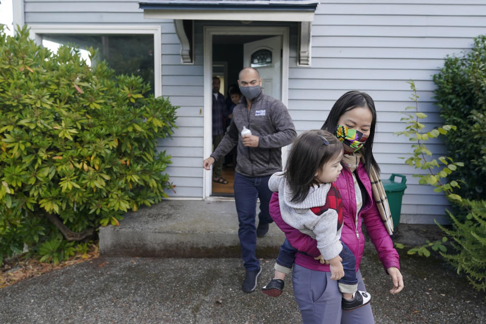 Thuy Do, right, walks with her husband, Jesse Robbins, left, and their son, Fredrick, Monday, Sept. 20, 2021. Do was nine years old when her family arrived in the United States from Vietnam in the 1980s, and that memory led Do and Robbins to reach out to assist Afghans fleeing their country. (AP Photo/Ted S. Warren)