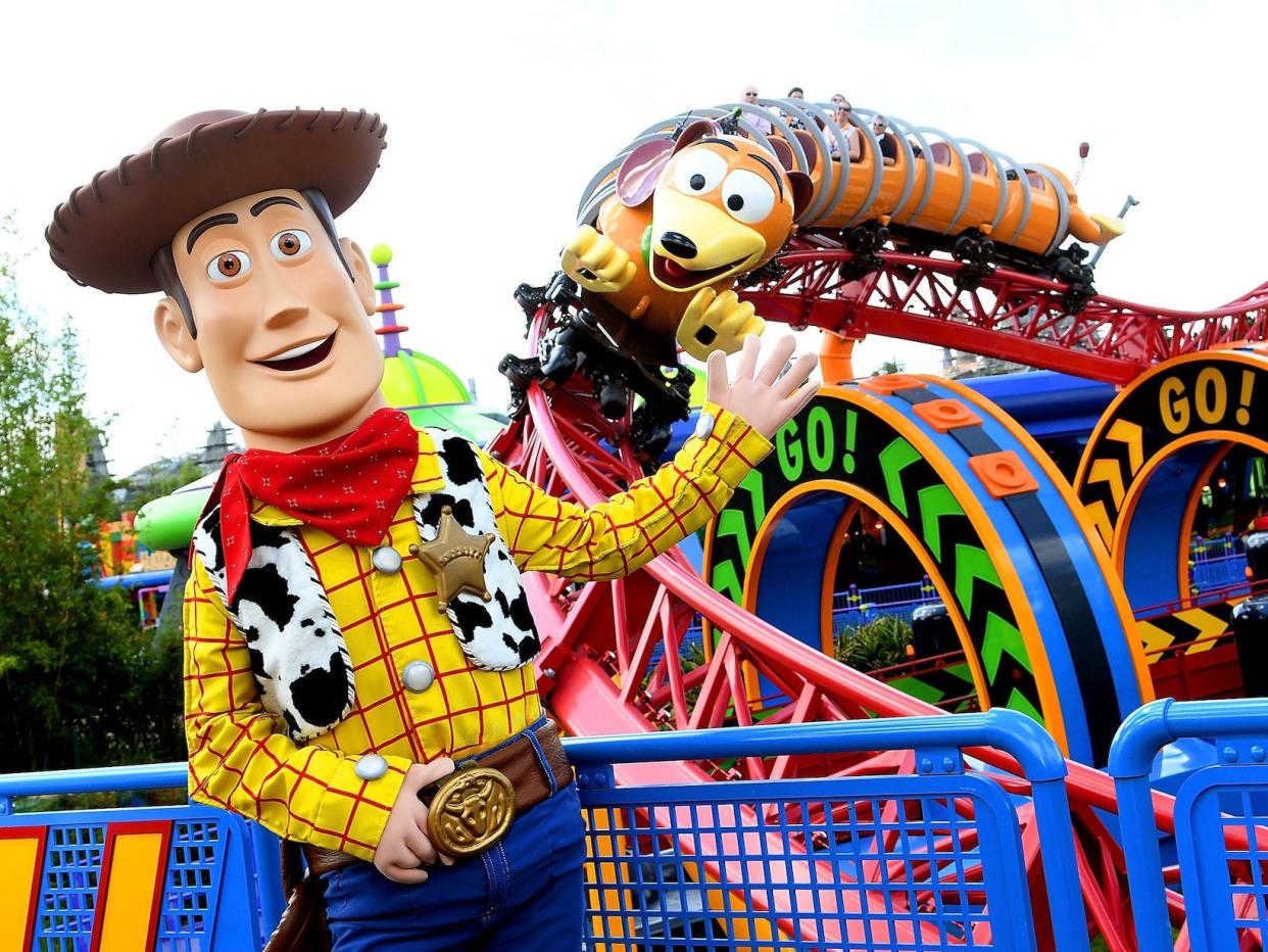 Woody from "Toy Story" stands in front of Slinky Dog Dash at Disney World in 2018.