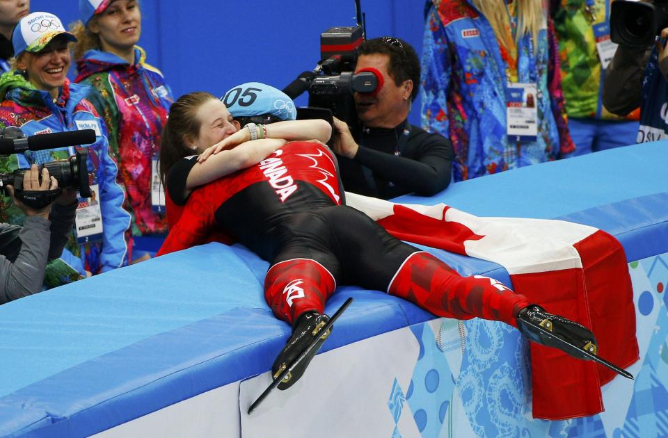 Winner Canada's Charles Hamelin hugs his girlfriend and compatriot speed skater Marianne St-Gelais after the men's 1,500 metres short track speed skating race finals at the Iceberg Skating Palace during the 2014 Sochi Winter Olympics