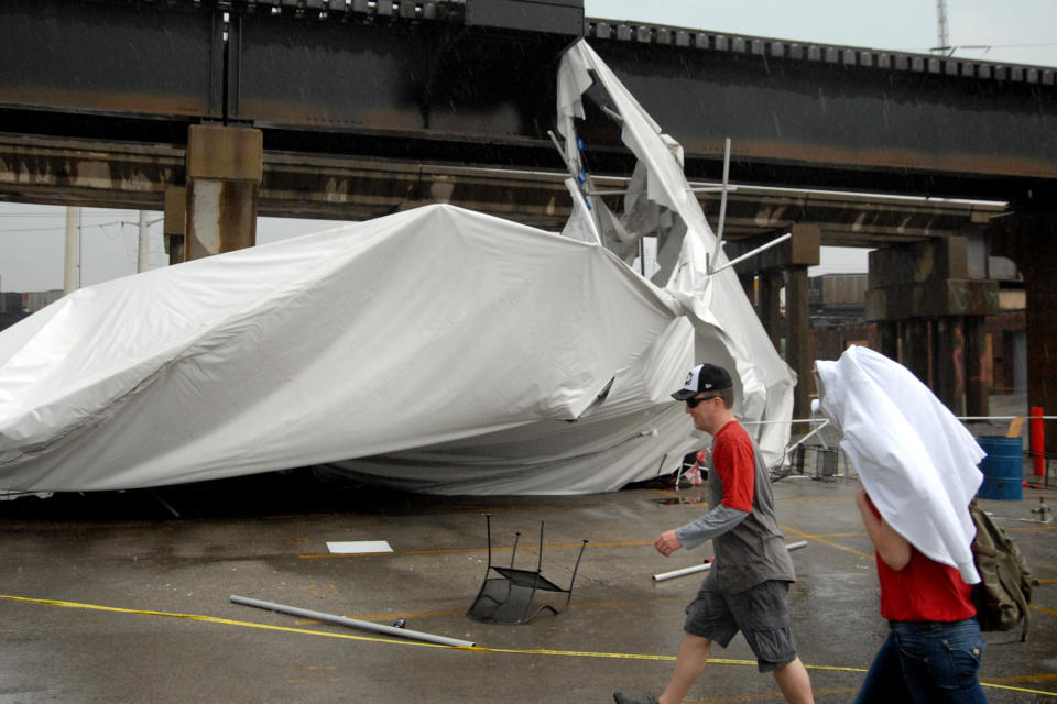 A party tent from Kilroy's Sports Bar in St. Louis rests against a railroad trestle near the bar after storm winds blew through the area following a baseball game between the St. Louis Cardinals and Milwaukee Brewers at nearby Busch Stadium Saturday, April 28, 2012. One person died Saturday and more than a dozen were taken to a hospital with injuries after high winds blew over a beer tent near Busch Stadium in St. Louis. (AP Photo/Sid Hastings)