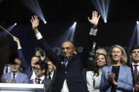 French far right presidential candidate Eric Zemmour, with his close adviser Sarah Knafo, third right, waves after his first rally, Sunday, Dec. 5, 2021 in Villepinte, north of Paris. Far-right former French TV pundit Eric Zemmour is holding his first campaign rally, a few days after he formally declared his candidacy for April's presidential election in a video relaying his anti-migrants, anti Islam views. A first round is to be held on April, 10, 2022 and should no candidate win a majority of the vote in the first round, a runoff will be held between the top two candidates on April 24, 2022. (AP Photo/Rafael Yaghobzadeh)