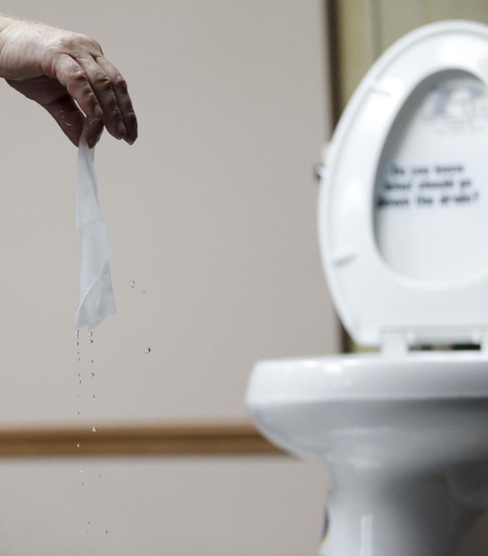 In this photograph taken, Friday, Sept. 20, 2013, in Middlesex, N.J., Rob Villee, executive director of the Plainfield Area Regional Sewer Authority in New Jersey, holds up a wipe he flushed through his test toilet in his office. Increasingly popular bathroom wipes, thick, premoistened towelettes that are advertised as flushable, are creating clogs and backups in sewer systems around the nation. The problem has gotten so bad in this upstate New York town that frustrated sewer officials traced the wipes back to specific neighborhoods, and even knocked on doors to break the embarrassing news to residents that they are the source of a costly, unmentionable mess. An industry trade group this month revised its guidelines on which wipes can be flushed, and has come out with a universal stick-figure, do-not-flush symbol to put on packaging. (AP Photo/Julio Cortez)