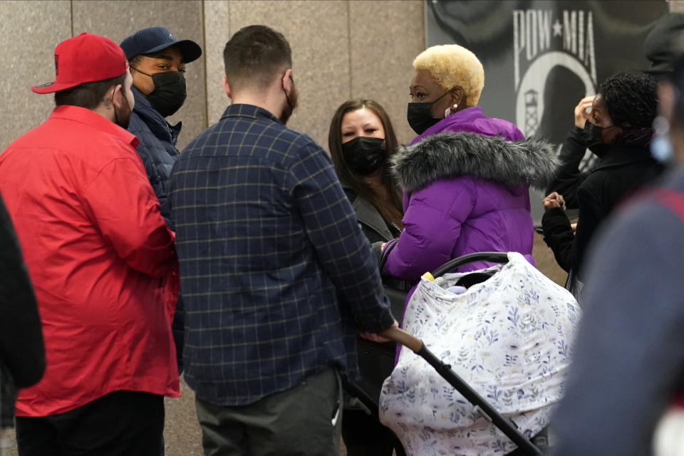 Katie Wright, the mother of Daunte Wright, center facing camera, and his father, Aubrey Wright, second from left, wait in line to go through security with other family members as they arrive Wednesday, Dec. 1, 2021 at the Hennepin County Government Center in Minneapolis for the second day of jury selection for former suburban Minneapolis police officer Kim Potter, who says she meant to grab her Taser instead of her handgun when she shot and killed motorist Daunte Wright. (AP Photo/Jim Mone)