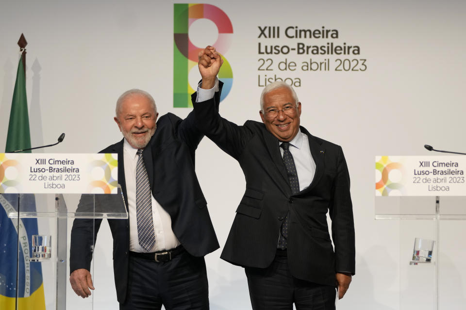 Brazilian President Luis Inacio Lula da Silva, left, takes the hand of Portuguese Prime Minister Antonio Costa after addressing journalists at the end of the Portugal-Brazil summit at the Belem Cultural Center in Lisbon, Saturday, April 22, 2023. Lula is in Lisbon for a four day state visit to Portugal. (AP Photo/Armando Franca)