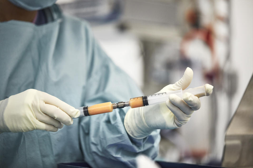 A doctor filling a syringe