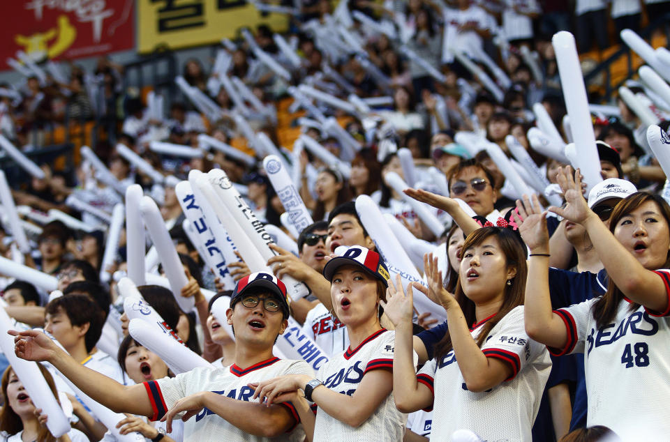 FILE- Fans of the South Korean baseball team Doosan Bears sing songs while performing dance routines at Jamsil Stadium in Seoul, South Korea, on Sept. 6, 2012. (AP Photo/Hye Soo Nah, File)