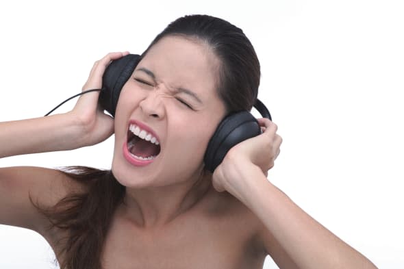 Young woman wearing headphones, screaming