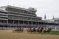 Horses come through the first turn during the 148th running of the Kentucky Derby horse race at Churchill Downs Saturday, May 7, 2022, in Louisville, Ky. Rich Strike, left rear, ridden by Sonny Leon, won the race. (AP Photo/Charlie Neibergall)