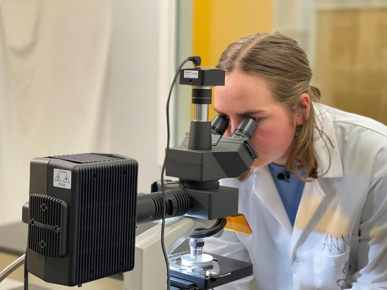 Anna Ryan, a 24-year-old masters student at Dalhousie University, examines microplastics samples she collected during Hurricane Larry in September 2021.  (Eric Woolliscroft/CBC - image credit)
