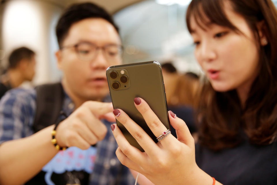 A customer touches an Apple's new iPhone 11 Pro Max after it went on sale at the Apple Store in Beijing, China, September 20, 2019. REUTERS/Jason Lee