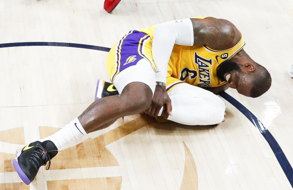 Los Angeles Lakers forward LeBron James lays on the court after injuring his leg during the second half of Game 2 in the Western Conference finals against the Denver Nuggets at Ball Arena in Denver on May 18, 2023. (Robert Gauthier / Los Angeles Times via Getty Images)
