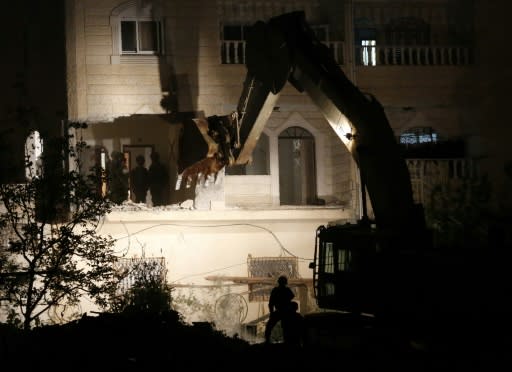 Israeli forces use a bulldozer to destroy two apartments that were home to the family of a Palestinian accused of the February killing of an Israeli woman in a pre-dawn operation in the flashpoint West Bank city of Hebron