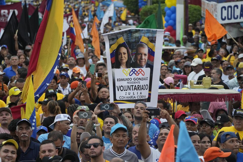 ARCHIVO - Un seguidor con una pancarta con la imagen de la líder de la oposición María Corina Machado y del candidato presidencial Edmundo González, en un acto de campaña en Maracaibo, Venezuela, el 2 de mayo de 2024. (AP Foto/Ariana Cubillos, Archivo)