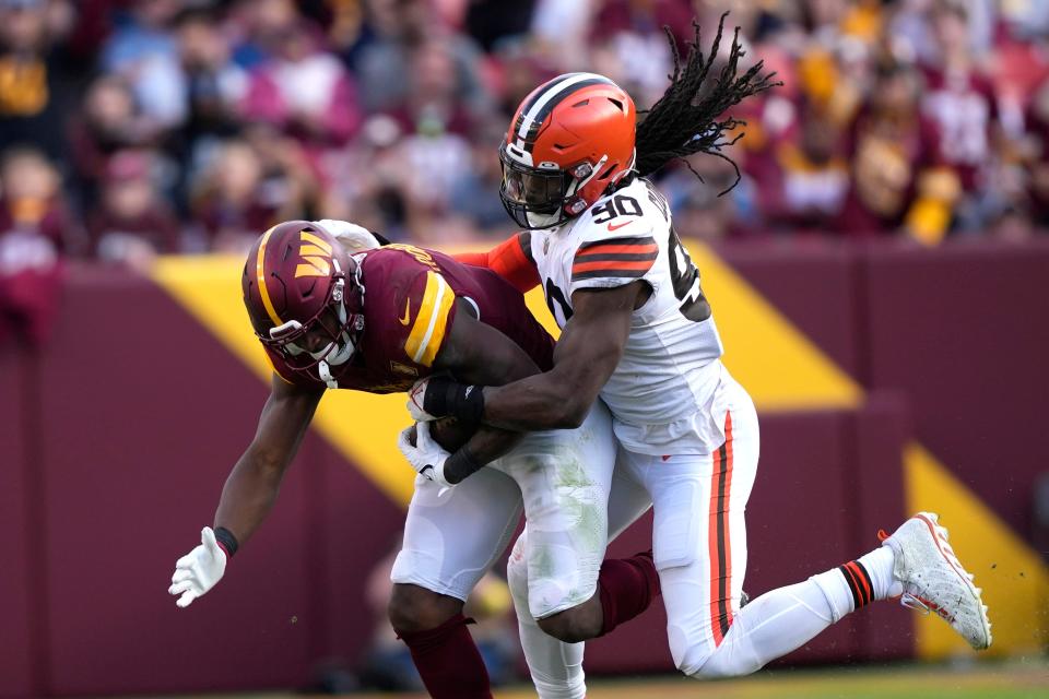 Cleveland Browns defensive end Jadeveon Clowney (90) tackles Washington Commanders running back Brian Robinson Jr. (8) during the second half of an NFL football game, Sunday, Jan. 1, 2023, in Landover, Md. (AP Photo/Susan Walsh)