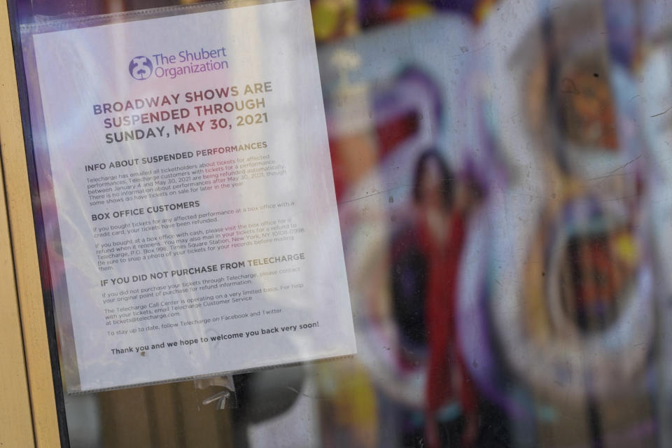 A sign hanging at the box office of a Theatre advises patrons that the Broadway shows are suspended, Sunday, Jan. 10, 2021, in the Hell's Kitchen neighborhood of New York. The boarded-up windows and For Rent signs are all over the place in Manhattan’s Hell’s Kitchen neighborhood. Nearby, the Broadway theaters are all dark. But the economic darkness brought on by the coronavirus pandemic has had a few bright spots. A couple of well-loved venues have gotten financial boosts, thanks to online fundraising campaigns and even a telethon. (AP Photo/Mary Altaffer)