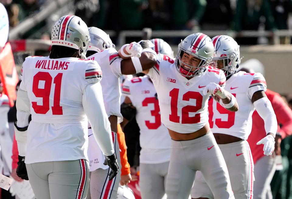 Oct 8, 2022; East Lansing, Michigan, USA; Ohio State Buckeyes safety Lathan Ransom (12) celebrates his interception with safety Josh Proctor (41) in the first quarter of the NCAA Division I football game between the Ohio State Buckeyes and Michigan State Spartans at Spartan Stadium. 