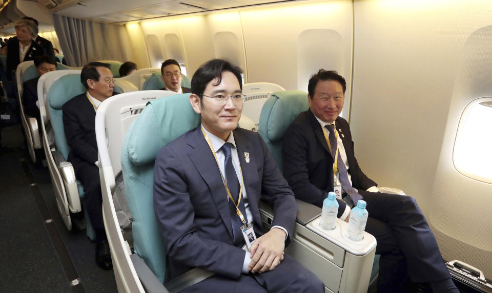 Samsung Electronics Vice Chairman Lee Jae-yong, center, and SK Group chairman Chey Tae-won, right, sit onboard a plane before leaving for Pyongyang, North Korea, with South Korean President Moon Jae-in at the Seoul military airport in Seongnam, South Korea, Tuesday, Sept. 18, 2018. (Pyongyang Press Corps Pool via AP)