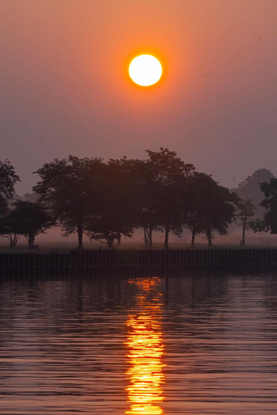 The sun rises over Veterans Park as smoke from the Canadian wildfires continues to linger in the air in Milwaukee on Friday morning.